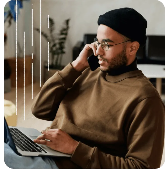 A man working on his laptop while on a phone call