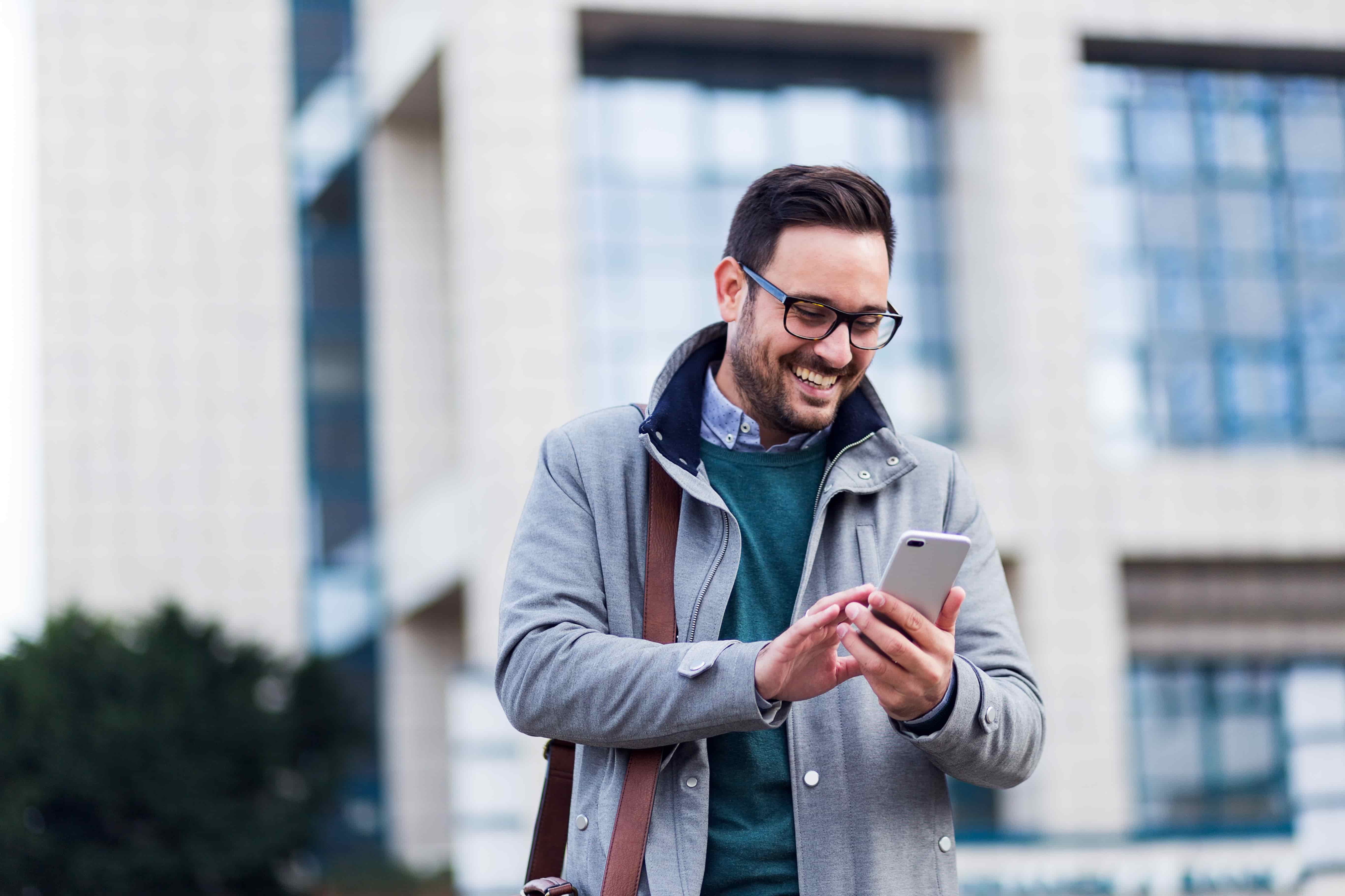 An employee participating in an online meeting from his phone outdoors