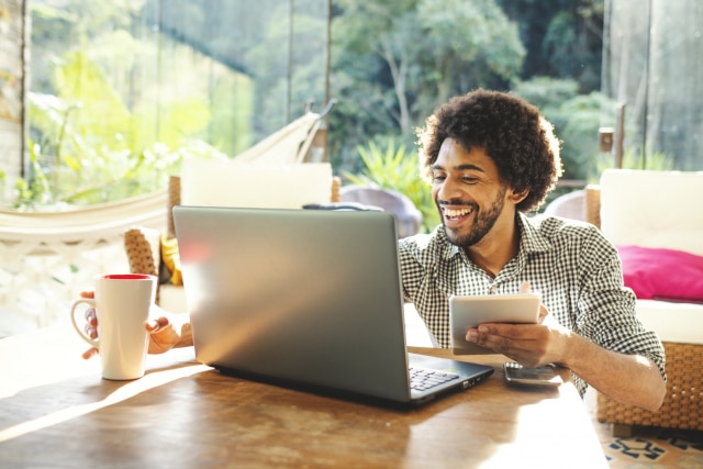 man using laptop in the living room to work from home