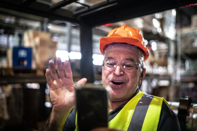 employee doing a video call on mobile phone at warehouse industry