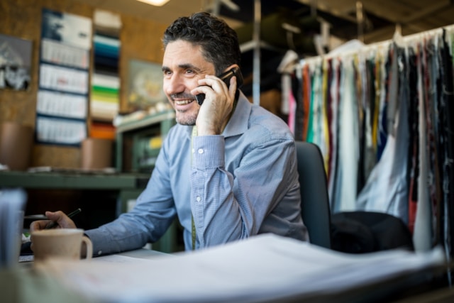 man in a clothes shop speaking on a mobile phone