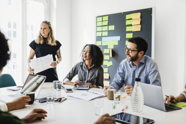 Group Of People Sitting At Conference Table During Office Presentation-886