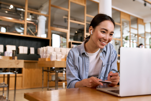 Young smiling Asian woman student watching online webinar training on laptop.-428