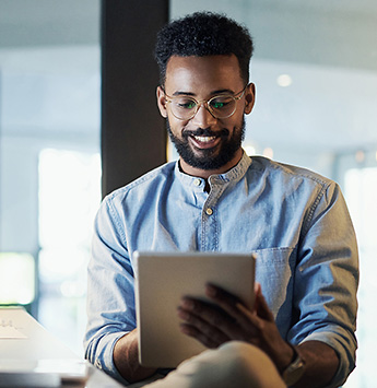 A man smiling while holding tablet